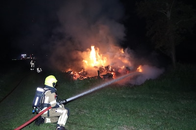 Felle brand in grote berg met gras en hout in Sprang-Capelle, brandweer is lang bezig met blussen