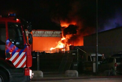 Gewonde bij zeer grote brand bij autobedrijf op industrieterrein in Raamsdonksveer, vuur onder contr