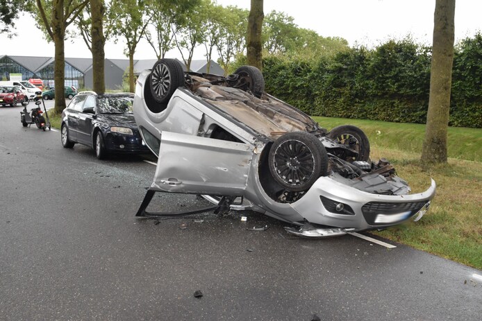 De auto kwam ondersteboven op het wegdek terecht.