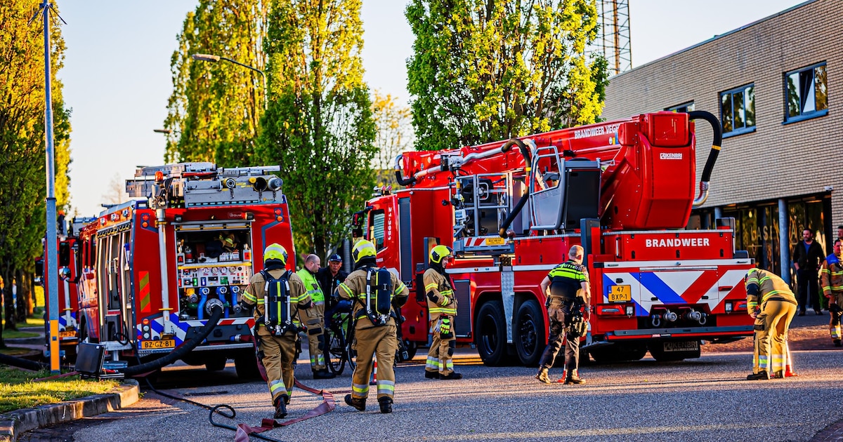 Machine vat vlam in bedrijfspand in Sint-Oedenrode, zwarte rookpluim vult gebouw