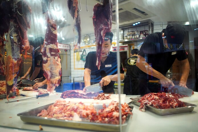 Restaurantmedewerkers snijden het vlees in een restaurant in Shenzhen.