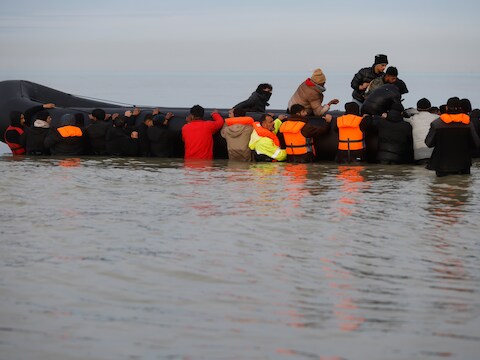 Een bootje met migranten strandt bij Groot-Brittannië. 