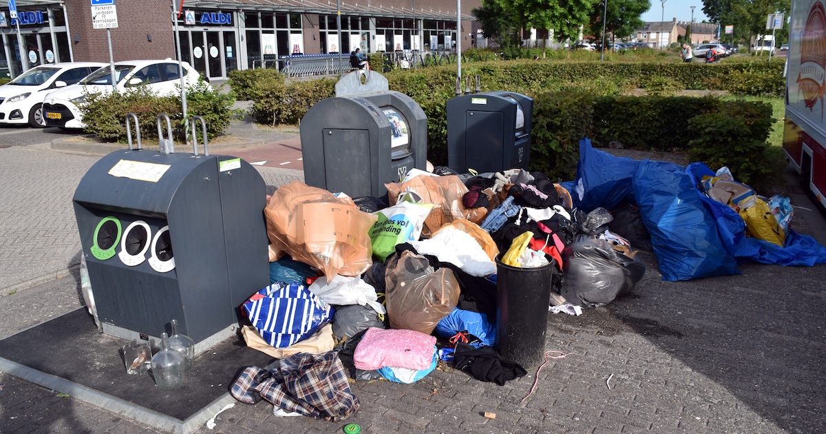 Zakken vol kleren achtergelaten naast afvalcontainers bij winkelcentrum in Zaltbommel