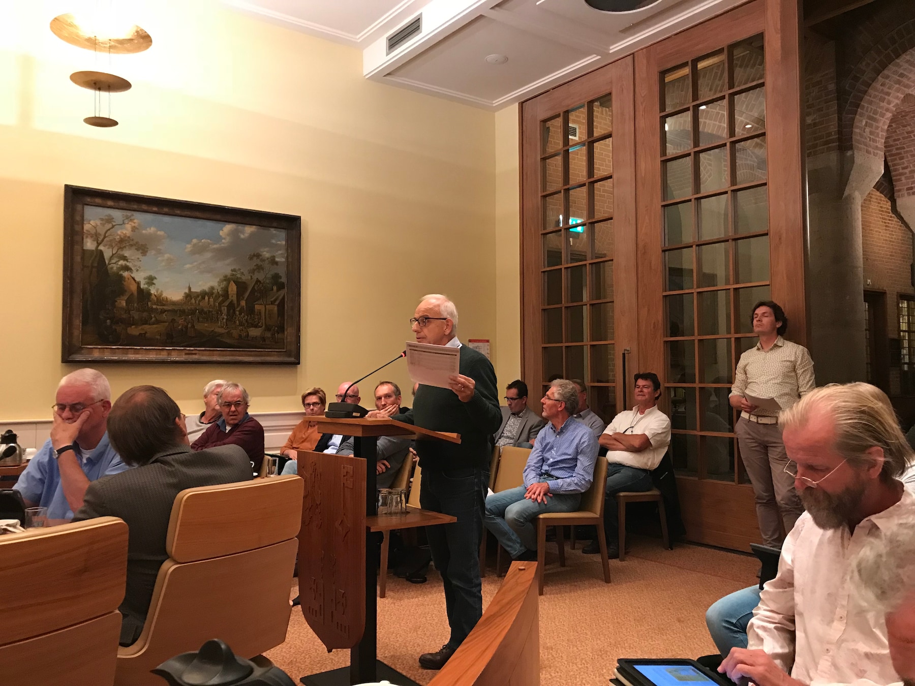 CDA-er en burgerlid Jeroen Kok (bij de deur) staat te wachten tot hij mag inspreken tijdens de commissie ruimte.