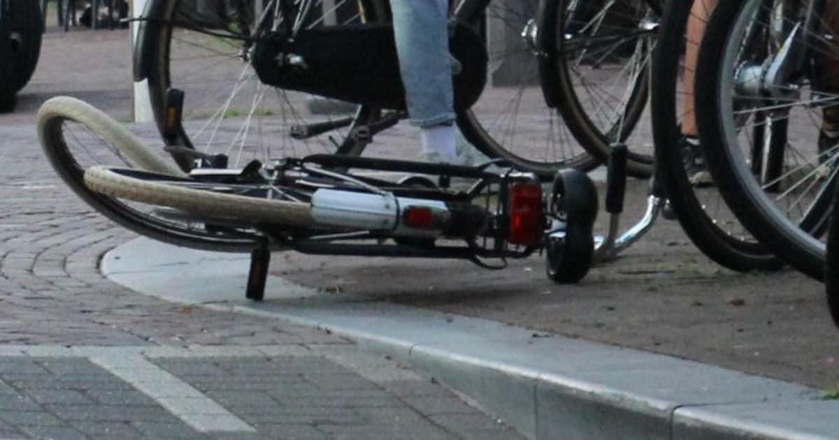 Fietser onderuit na botsing met scooter voor druk terras in Oss.