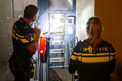 Vlammen bij portiek van flatcomplex geblust door politie in Oss, mogelijk iets brandends in brievenbus gestopt